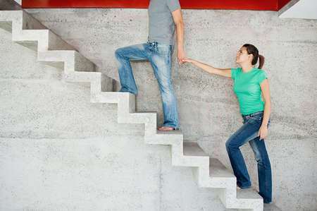A man leading a woman upward