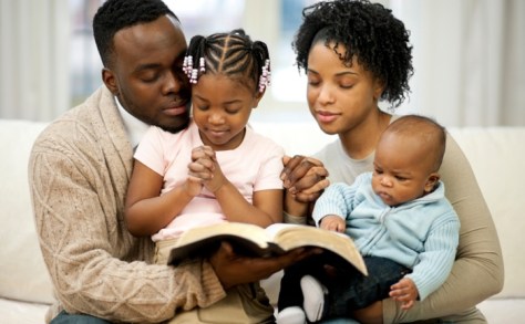 A family praying and reading the Bible
