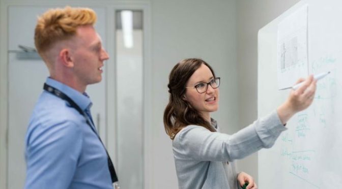 Woman Showing Her Work On Whiteboard